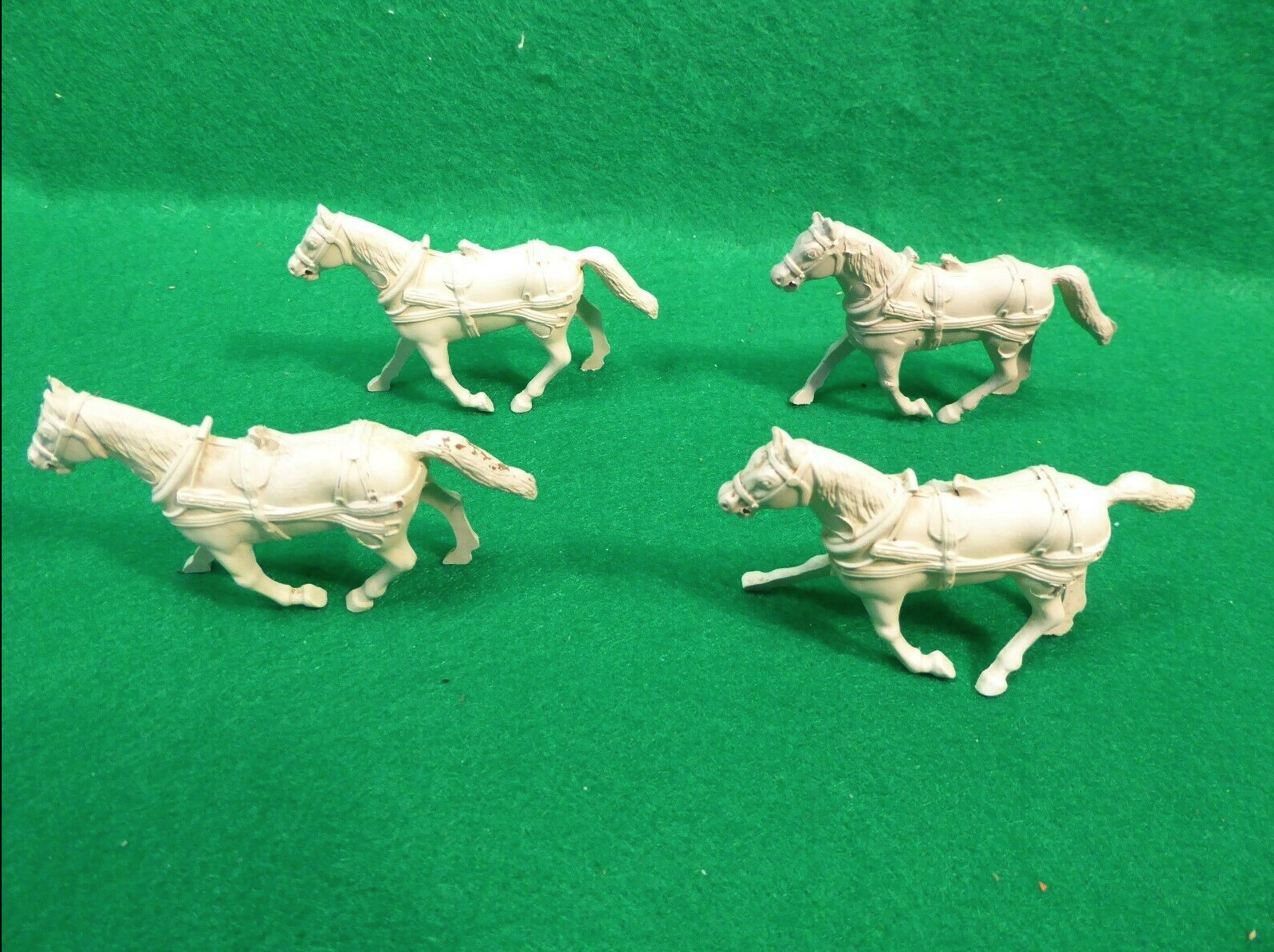 four white horses on green